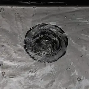 水流在黑色水槽排水口处盘旋向下的特写镜头