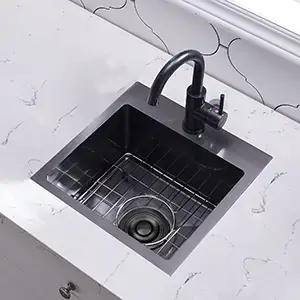 窗边白色大理石台面上的黑色台面式吧台水槽俯视图,配有黑色水龙头,底部已安装栅格